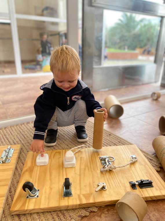 Un nene pequeño apilando materiales de madera en la sala